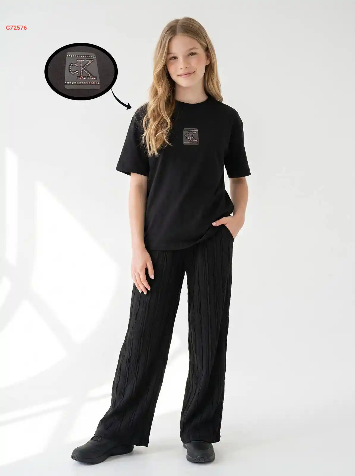 بيجامة كاجوال مريحة وعصرية من ماركة Calvin Klein (CK)، تتكون من تيشيرت قطني نصف كم بنقشة الشعار وبنطال أسود طويل مضلع